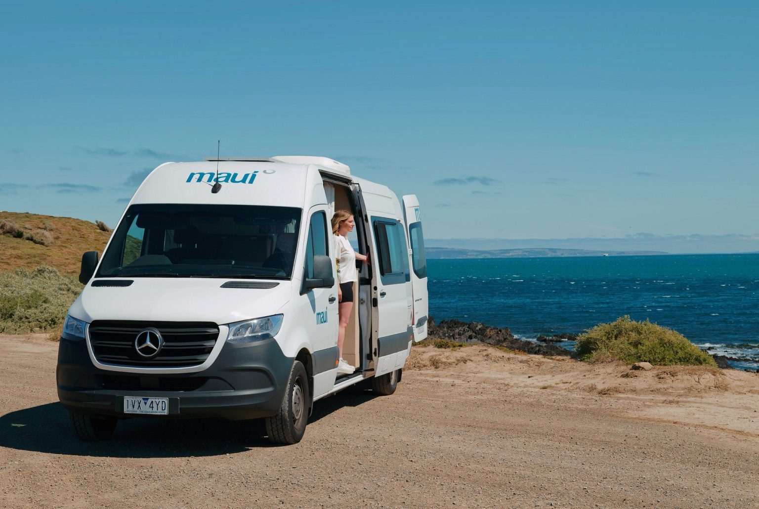 Campervan parked on a rocky coastline beside the sea, Cape Jervis, South Australia