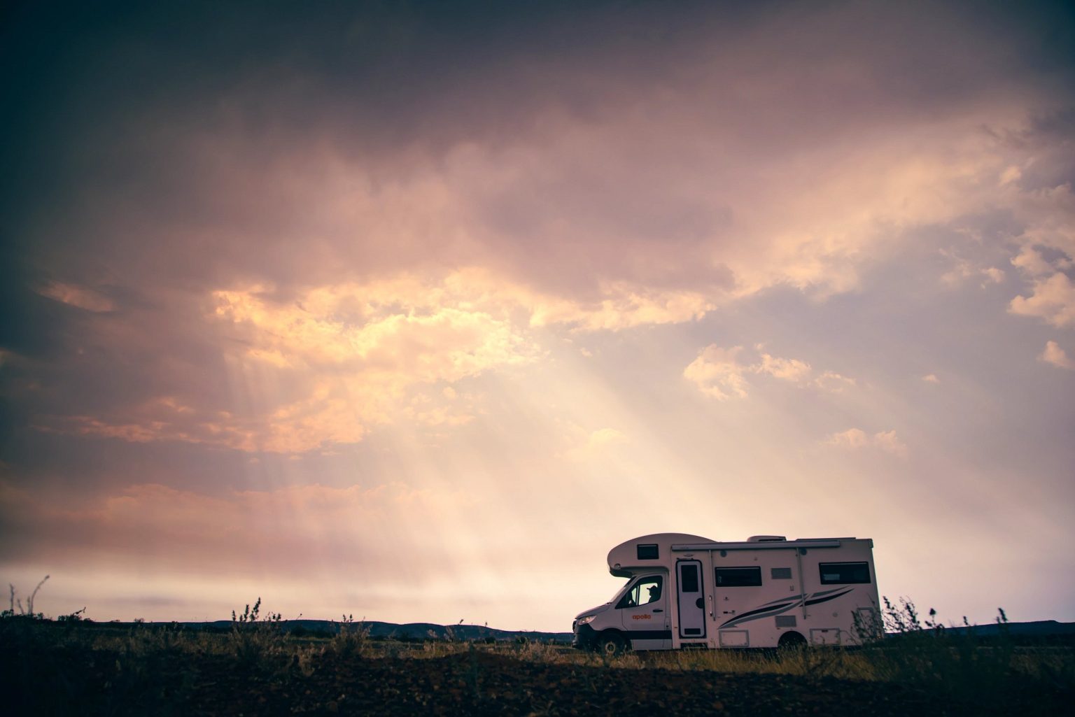 Motorhome parked under dramatic rays of evening light, Alice Springs, the Northern Territory