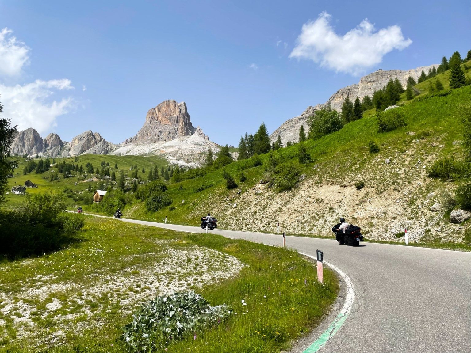Motorcyclists on a Dolomites pass road below the Cinque Torri
