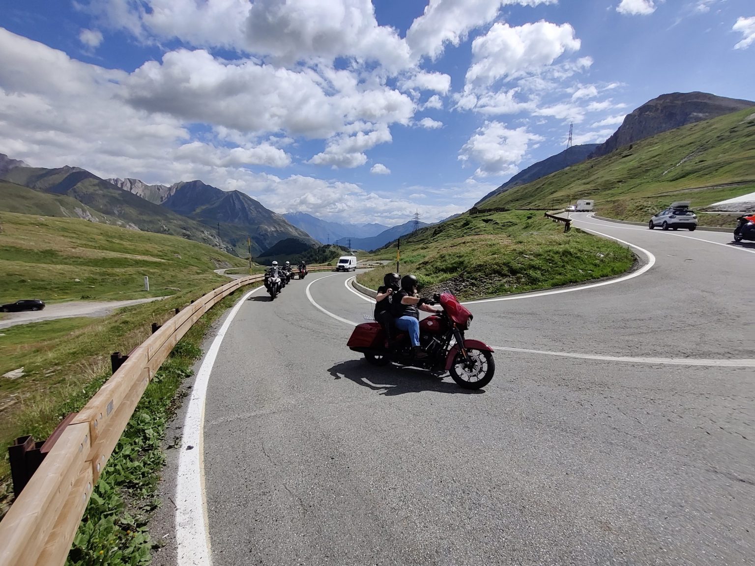Rider on a red touring motorcycle on an Alpine hairpin bend