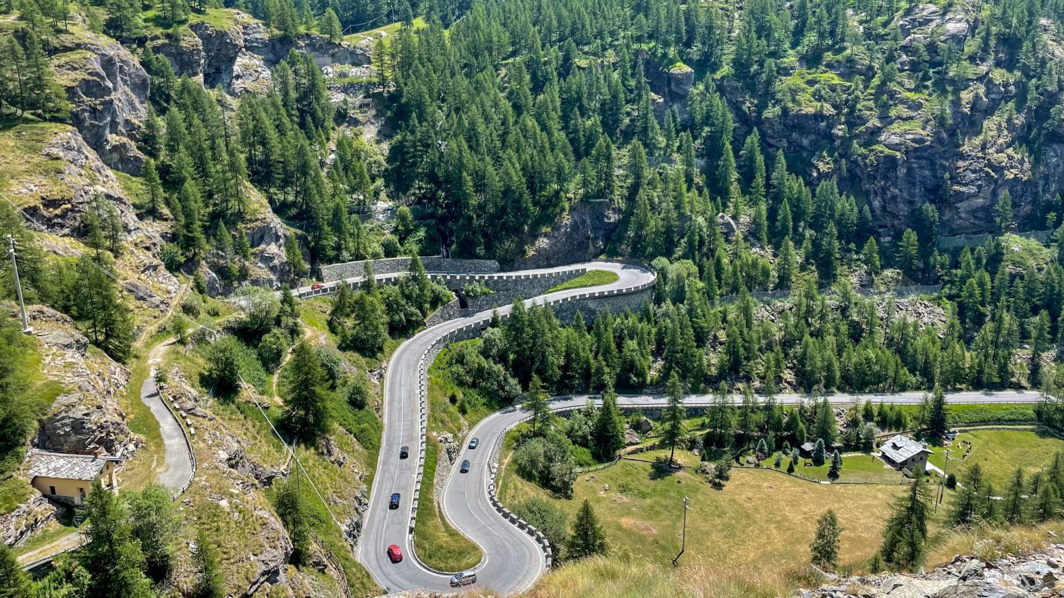 Switchback road through larch forest in the Italian Alps