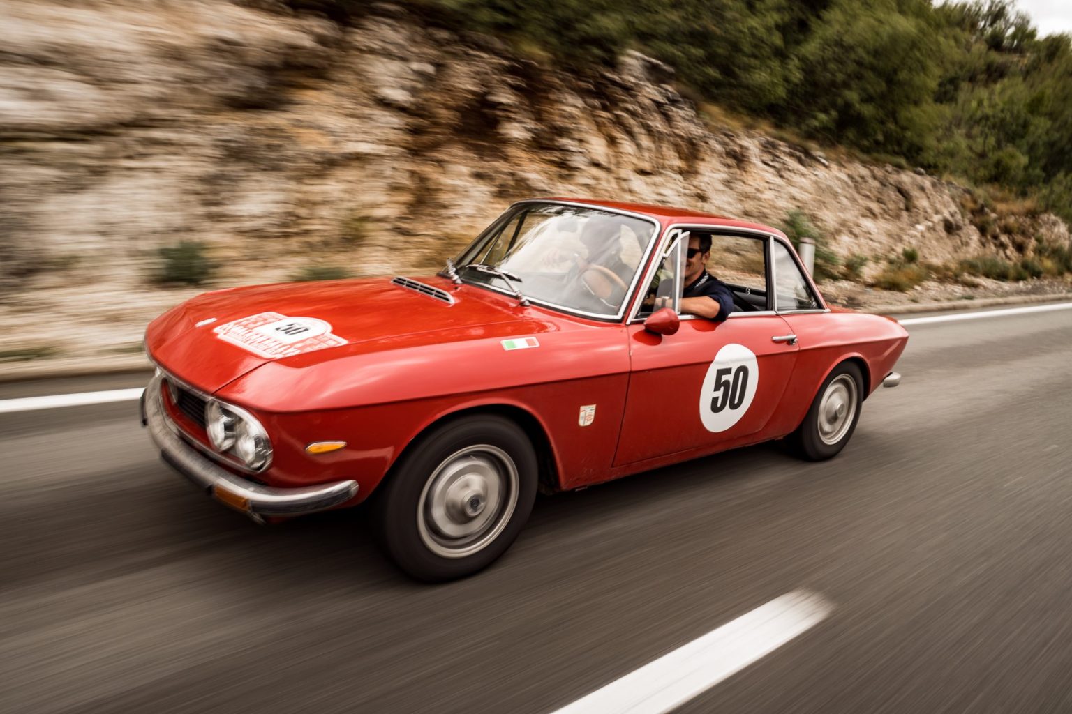 Red classic Alfa Romeo at speed on a Balkan Rally stage