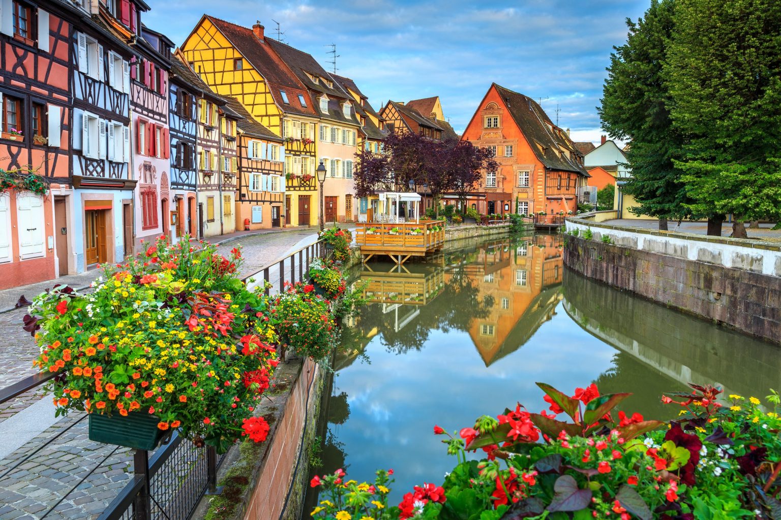 Half-timbered houses and flowers along a canal in Colmar, Alsace