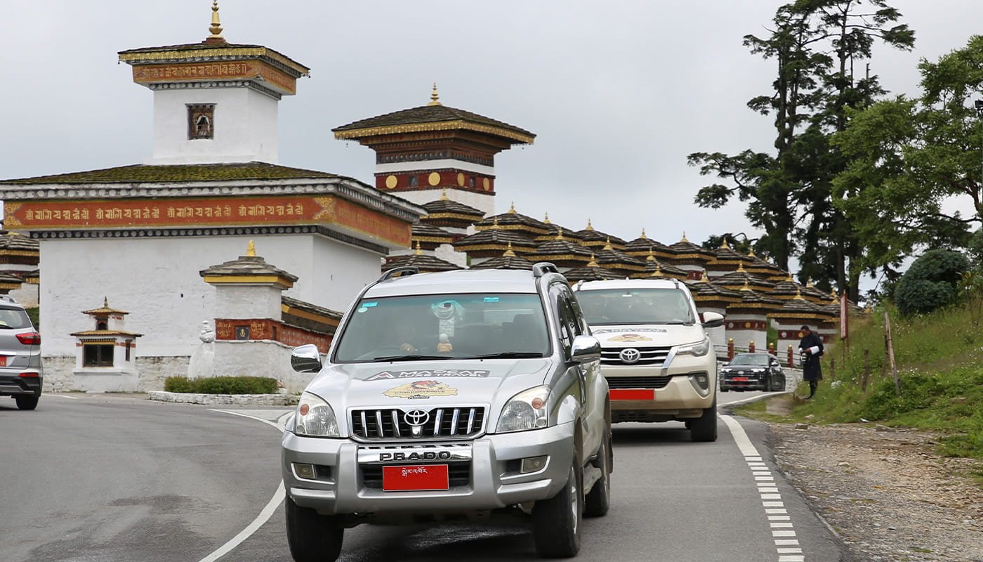 Toyota Land Cruisers outside a traditional Bhutanese temple