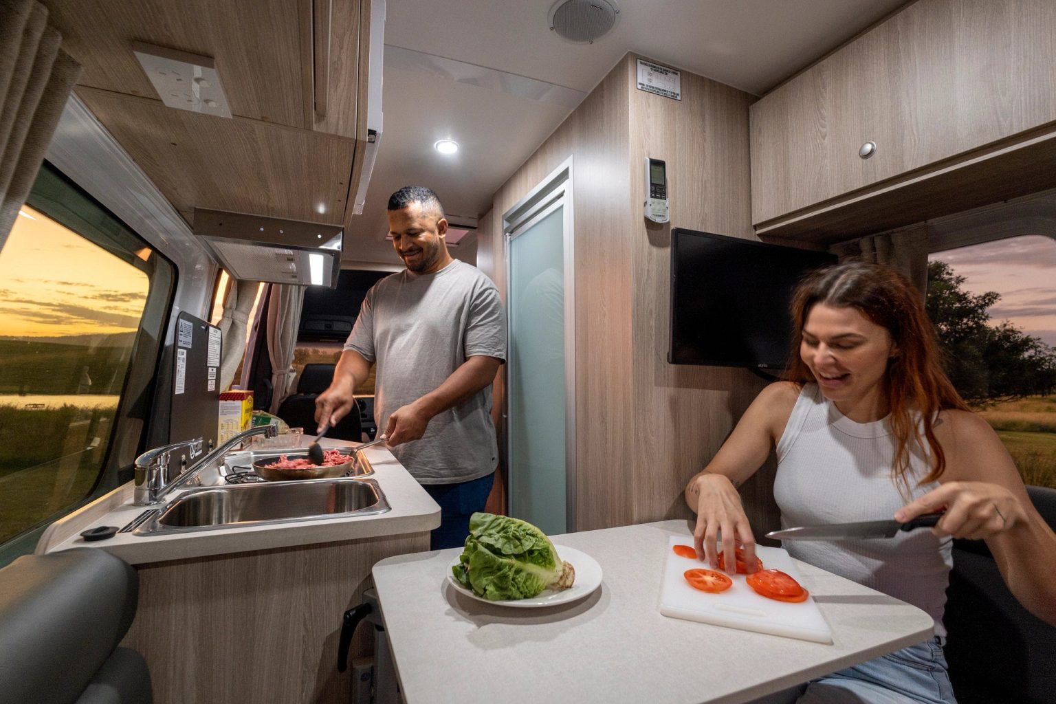 Couple preparing a salad in the motorhome kitchen, South East Queensland