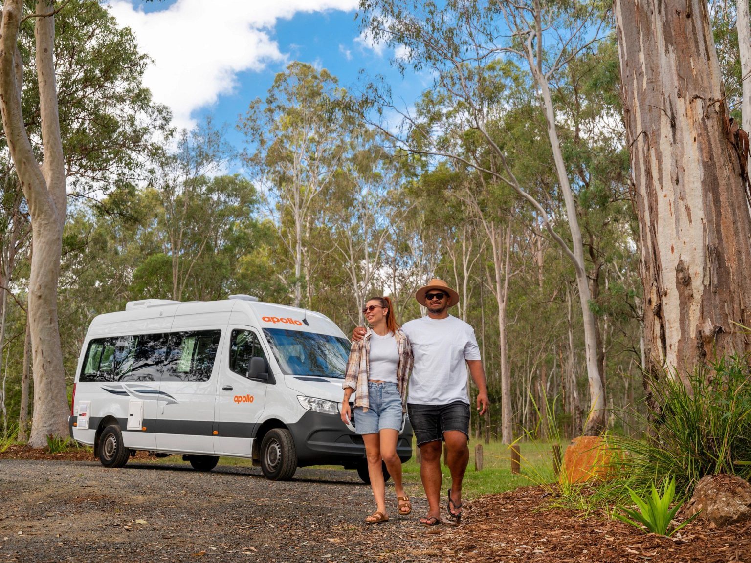 Couple walking from their campervan through bushland, South East Queensland