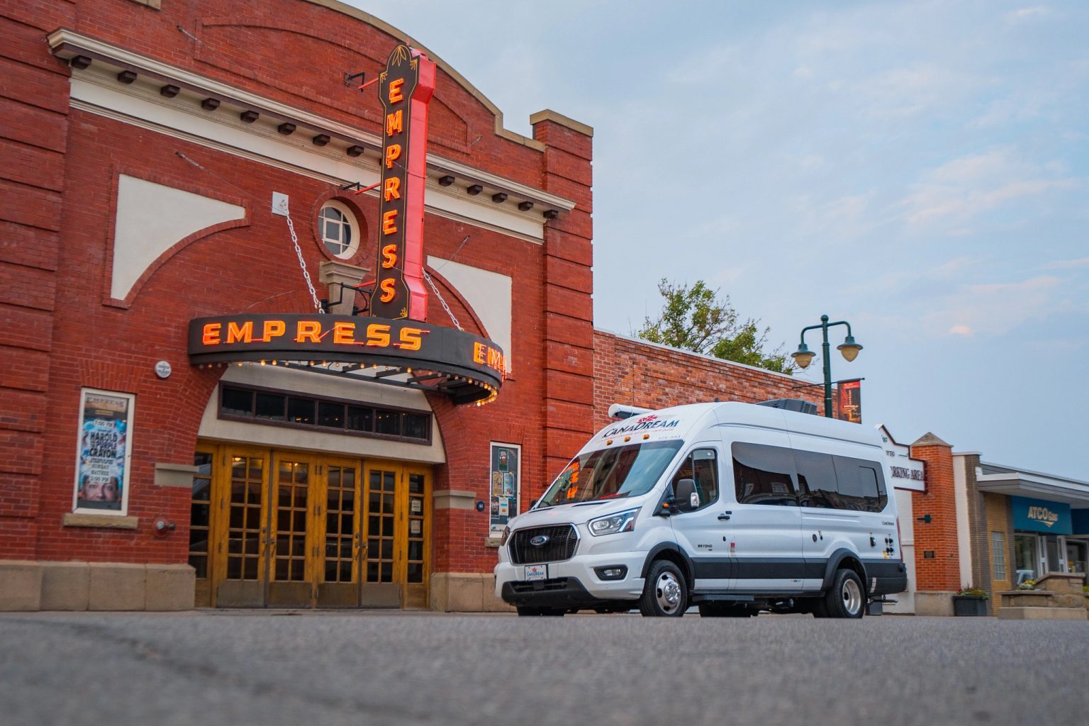 Campervan parked outside an ornate red-brick theatre, Alberta, Canada