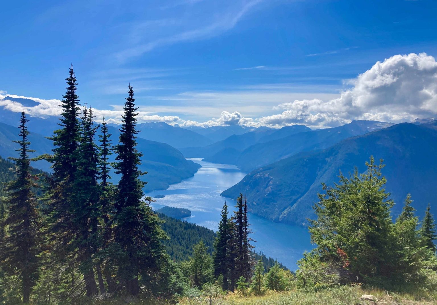 Deep blue mountain lake between forested slopes in the Rockies