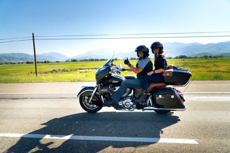 Couple riding a touring motorcycle on a mountain highway in British Columbia