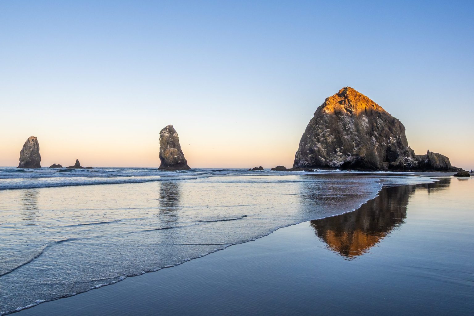 Haystack Rock reflected on the sand at Cannon Beach, Oregon