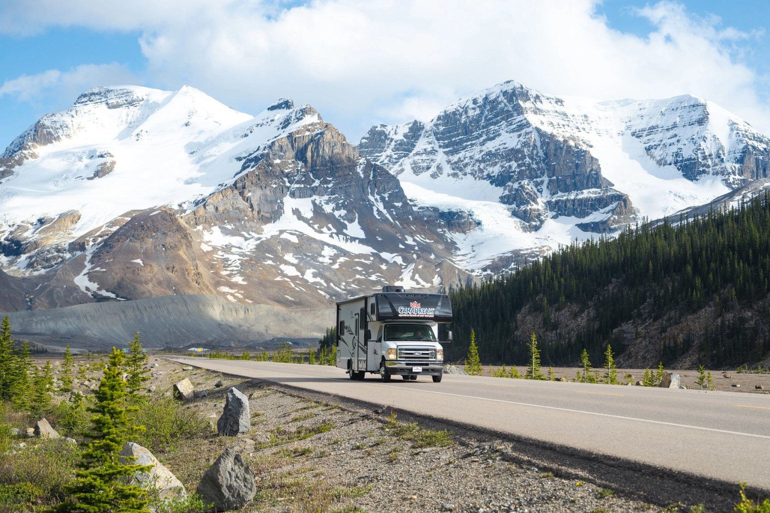 Motorhome on a highway below glaciated mountain peaks, Jasper, Canada