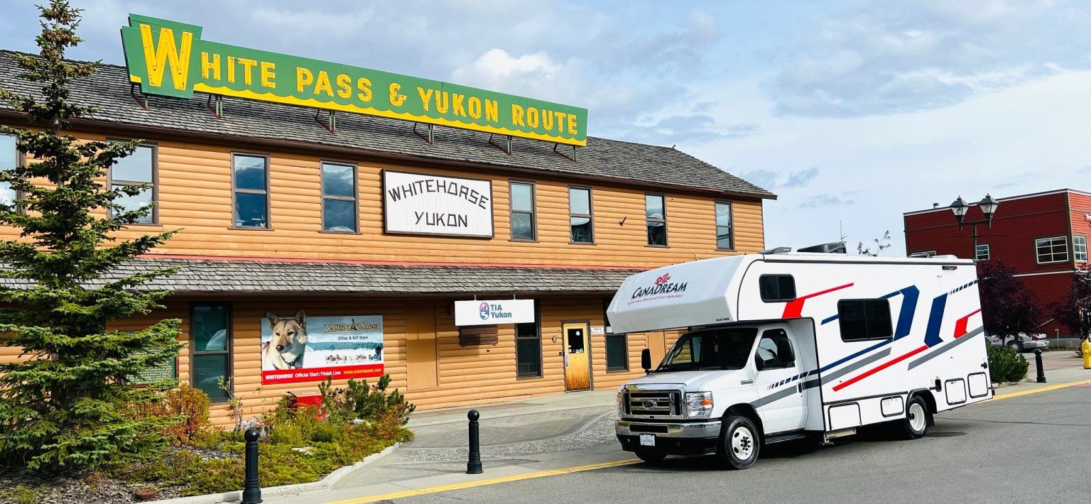 Motorhome parked outside a historic wooden railway building, Yukon, Canada
