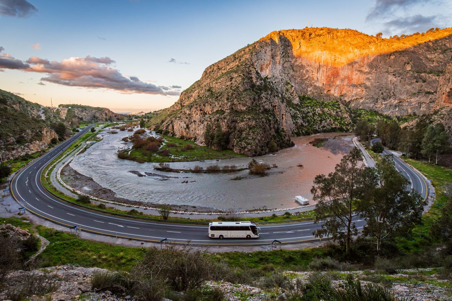 Mountain road looping beneath limestone cliffs in northern Spain