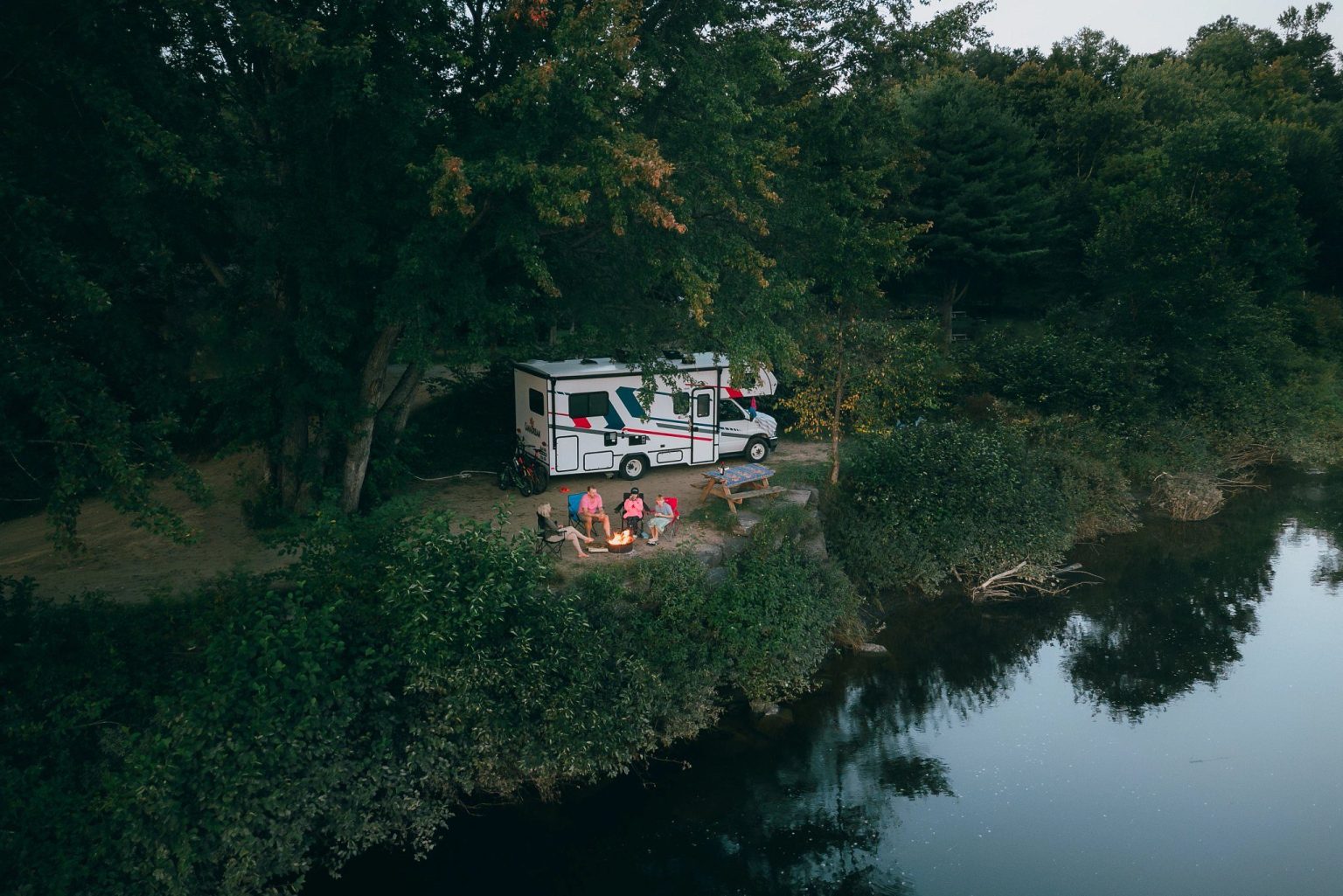 Motorhome parked by a quiet river in a forest, Ontario, Canada