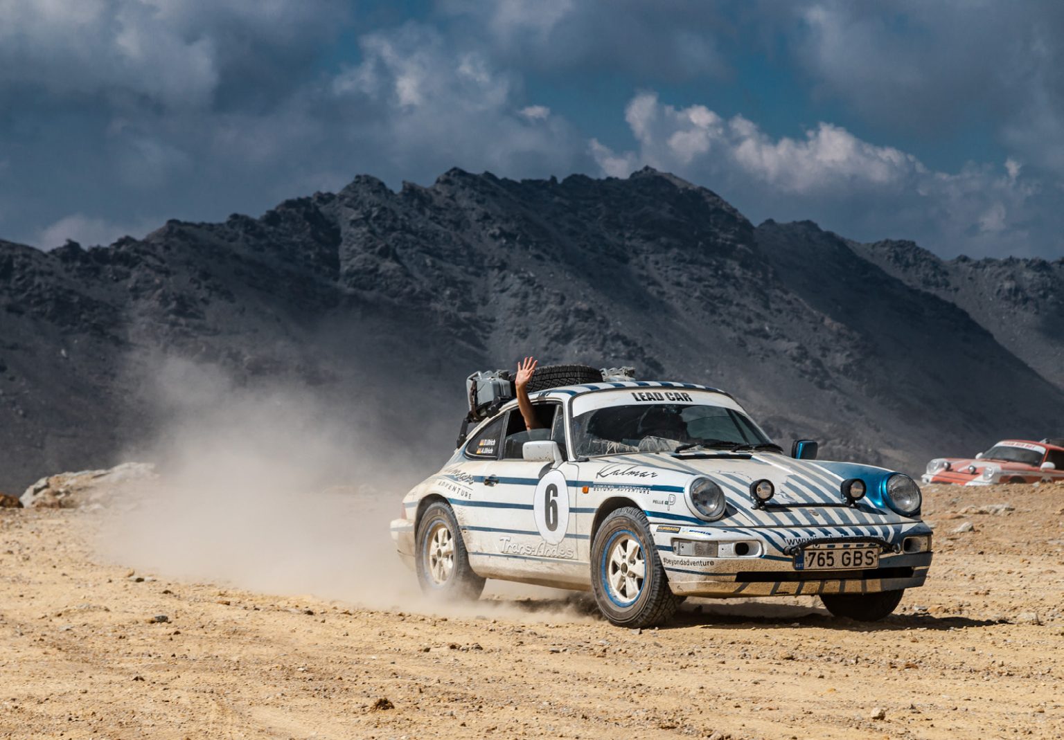 Porsche 911 safari car kicking up dust on a Himalayan mountain track