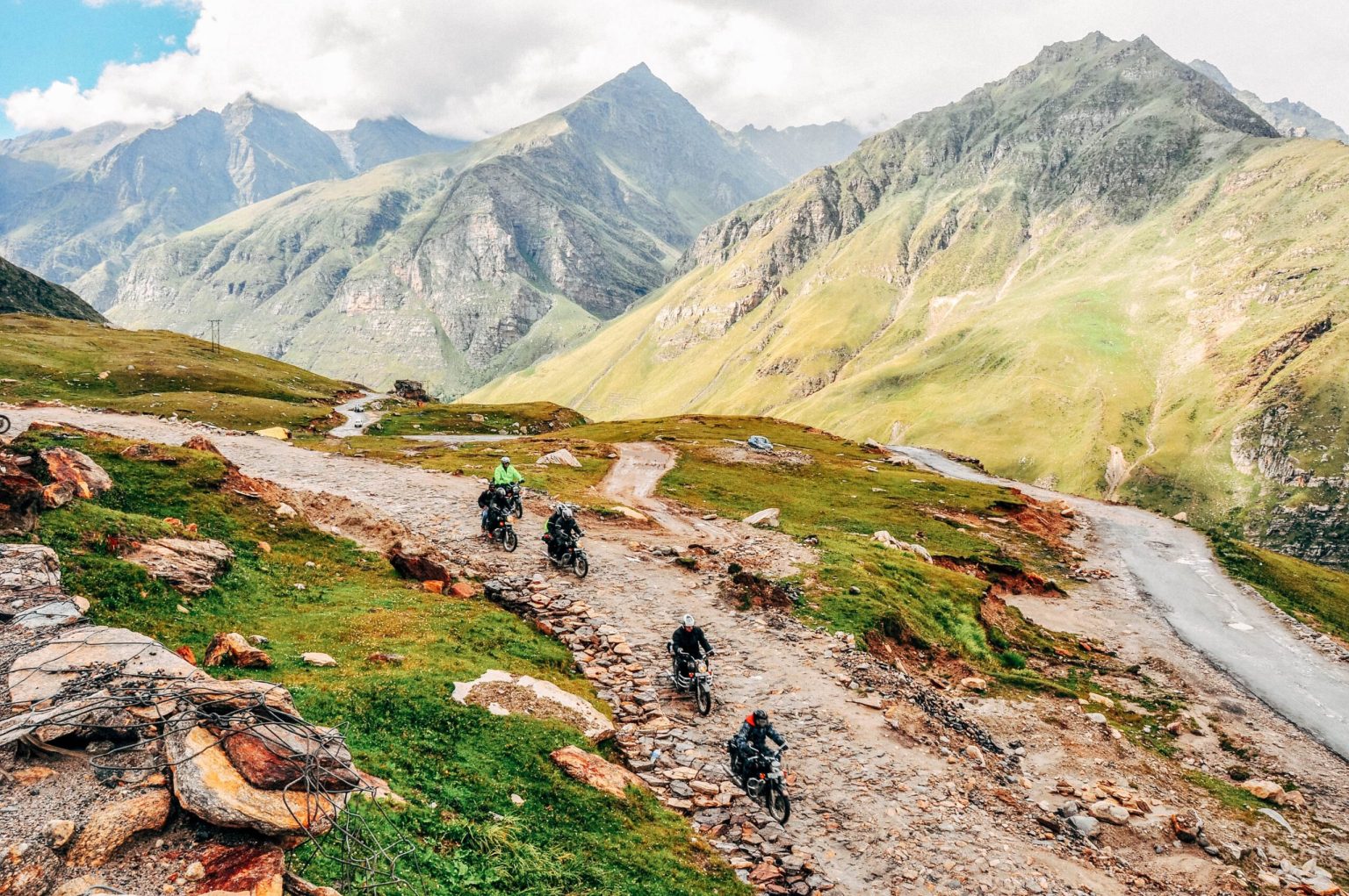 Riders on switchback roads below Himalayan peaks in Ladakh