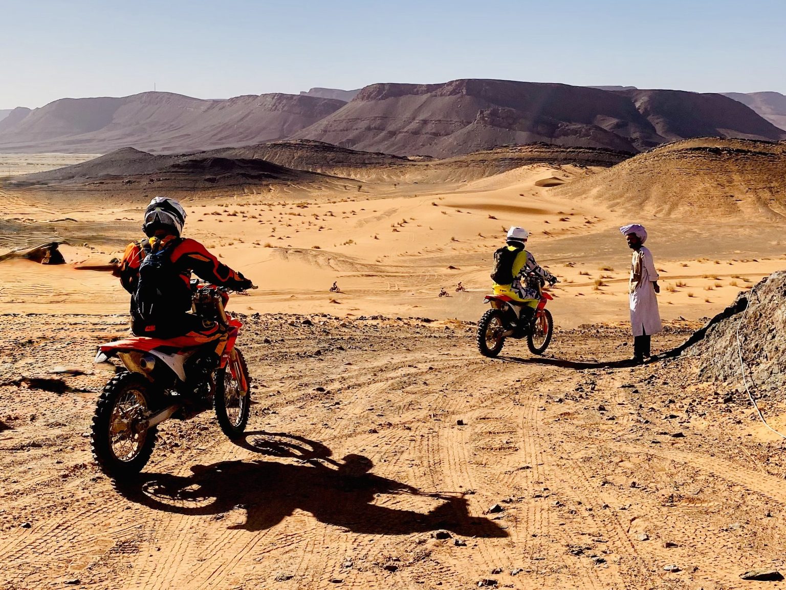 Riders crossing a wide desert valley in southern Morocco