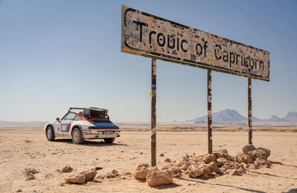 Rally Porsche at the Tropic of Capricorn sign in the Namibian desert