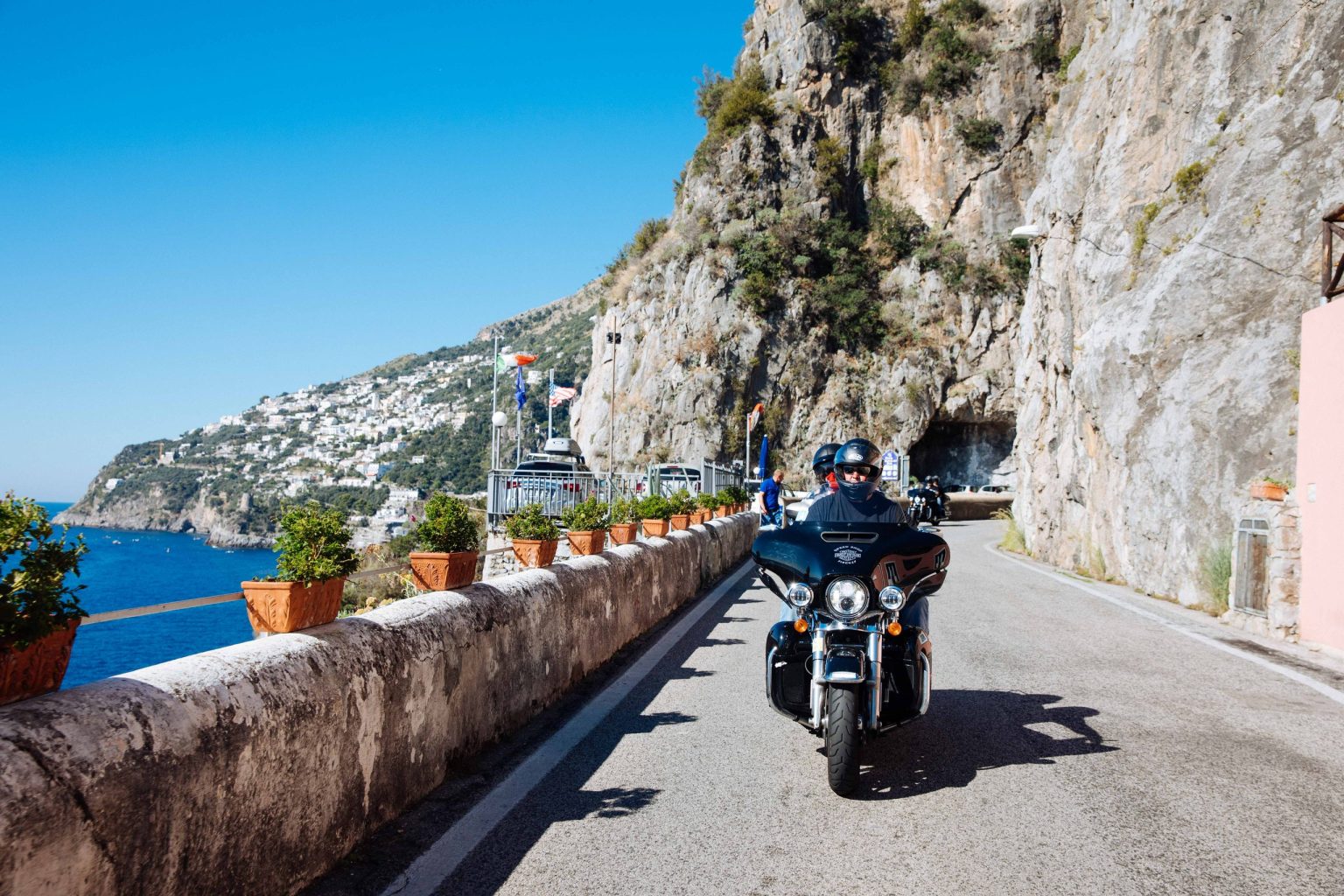 Rider on a touring Harley-Davidson on the cliffside Amalfi Coast road