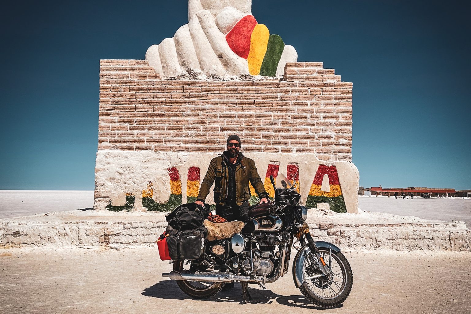 Rider with a classic motorcycle at the Dakar monument on the Uyuni salt flat