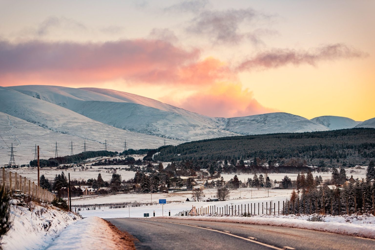 Dalwhinnie beneath snow-capped mountains at sunset