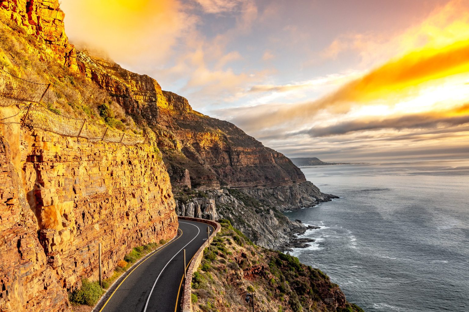 Chapman's Peak Drive curving along the cliffs above the Atlantic at sunset, Cape Town