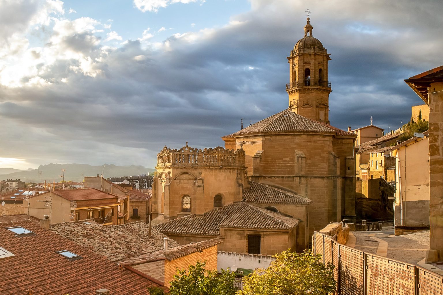Stone church tower above old-town rooftops in northern Spain