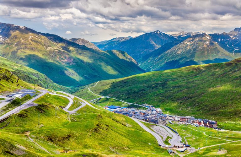 Mountain road winding through green valleys in the Pyrenees