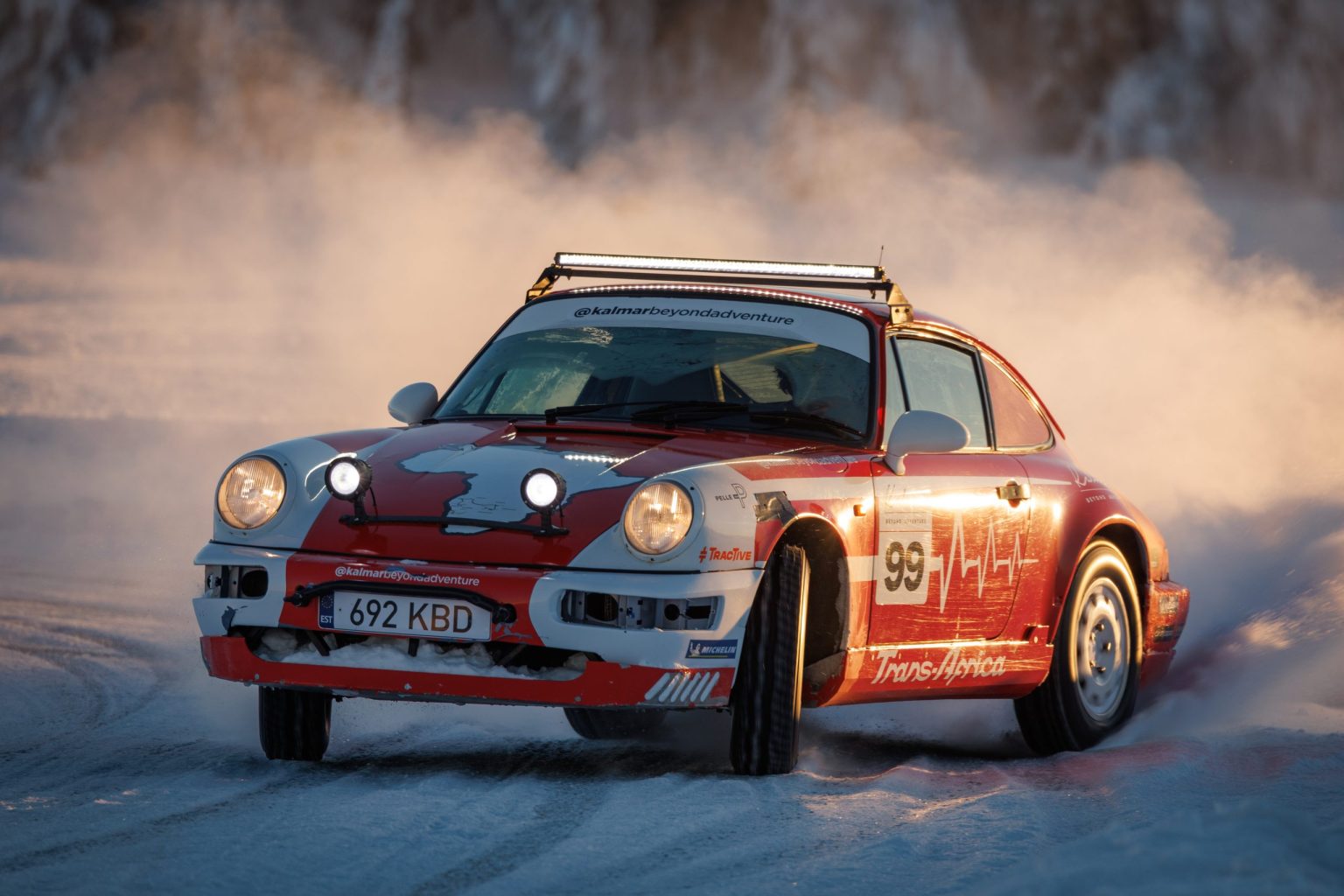 Safari-prepared Porsche 911 throwing up snow on an ice track in Lapland