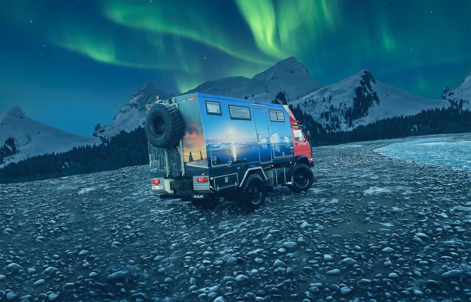 Painted expedition truck on a pebbly riverbank under green northern lights