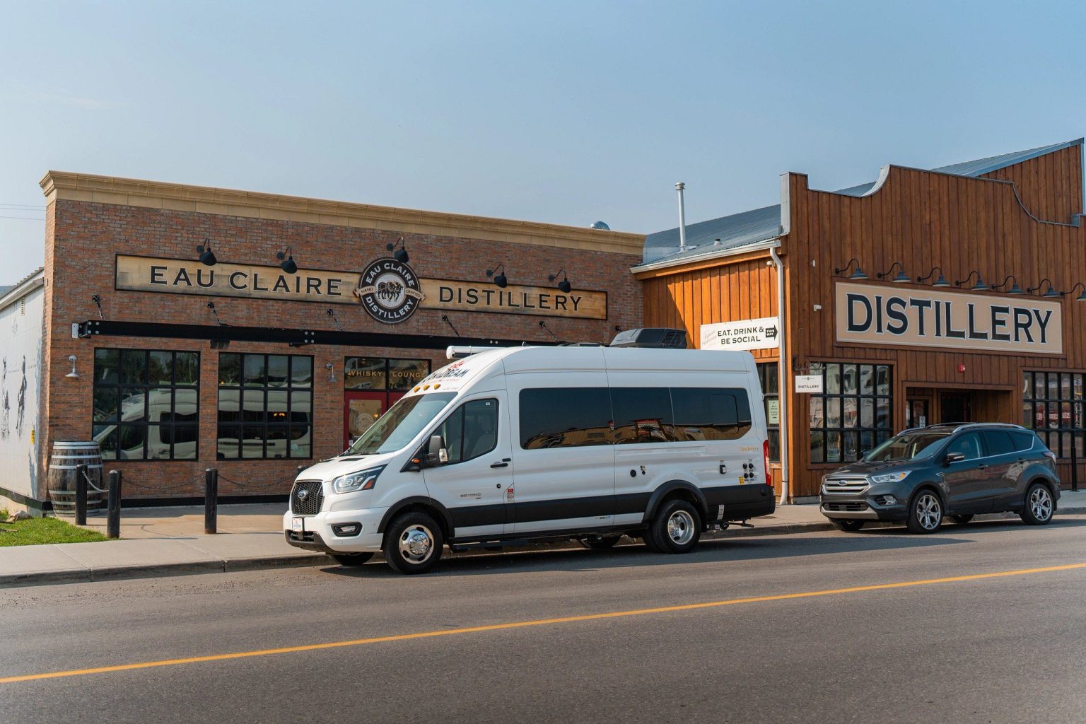 Campervan parked on a town street outside a distillery, Alberta, Canada