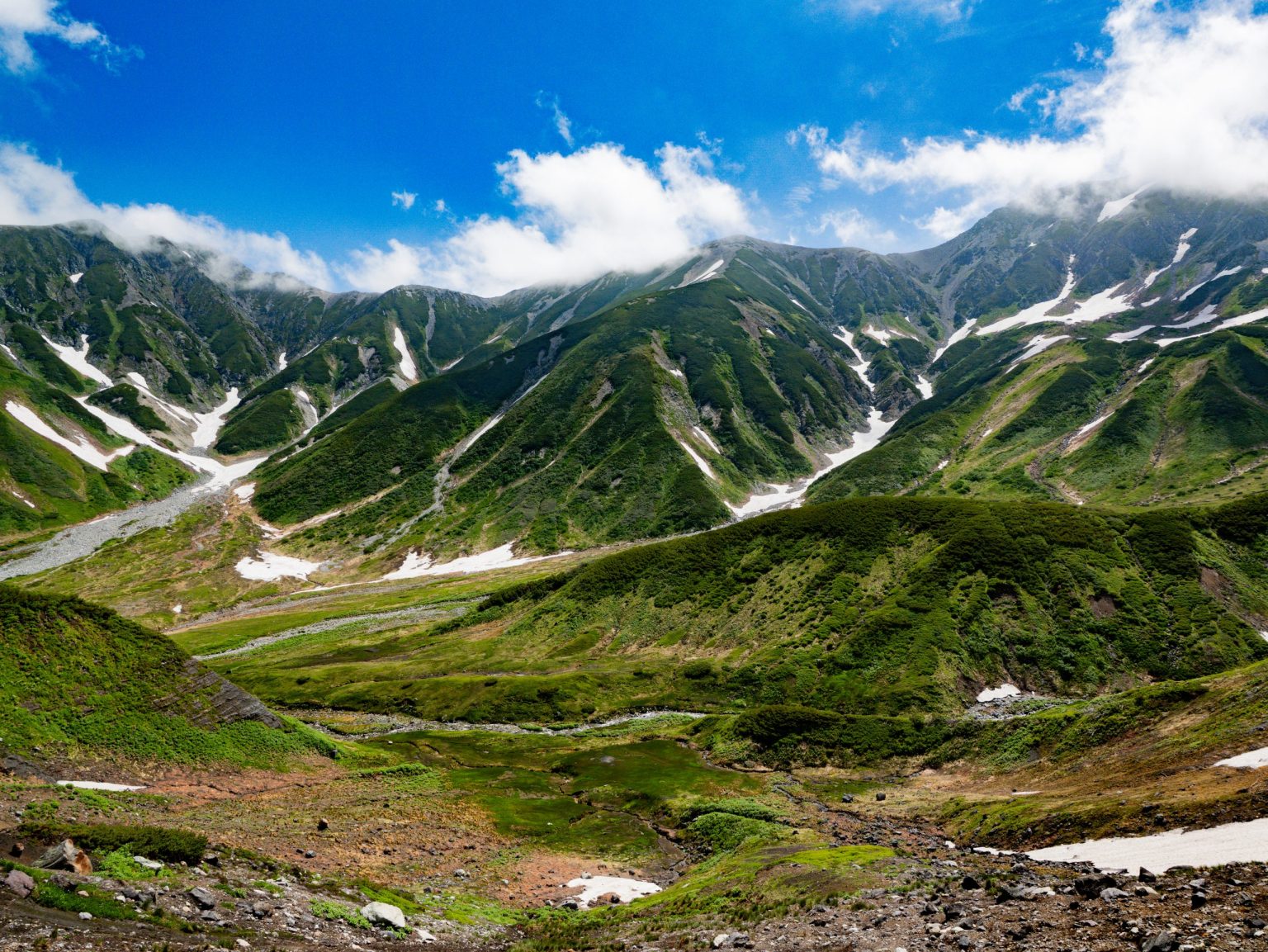 Green slopes and snow patches of the Northern Japanese Alps
