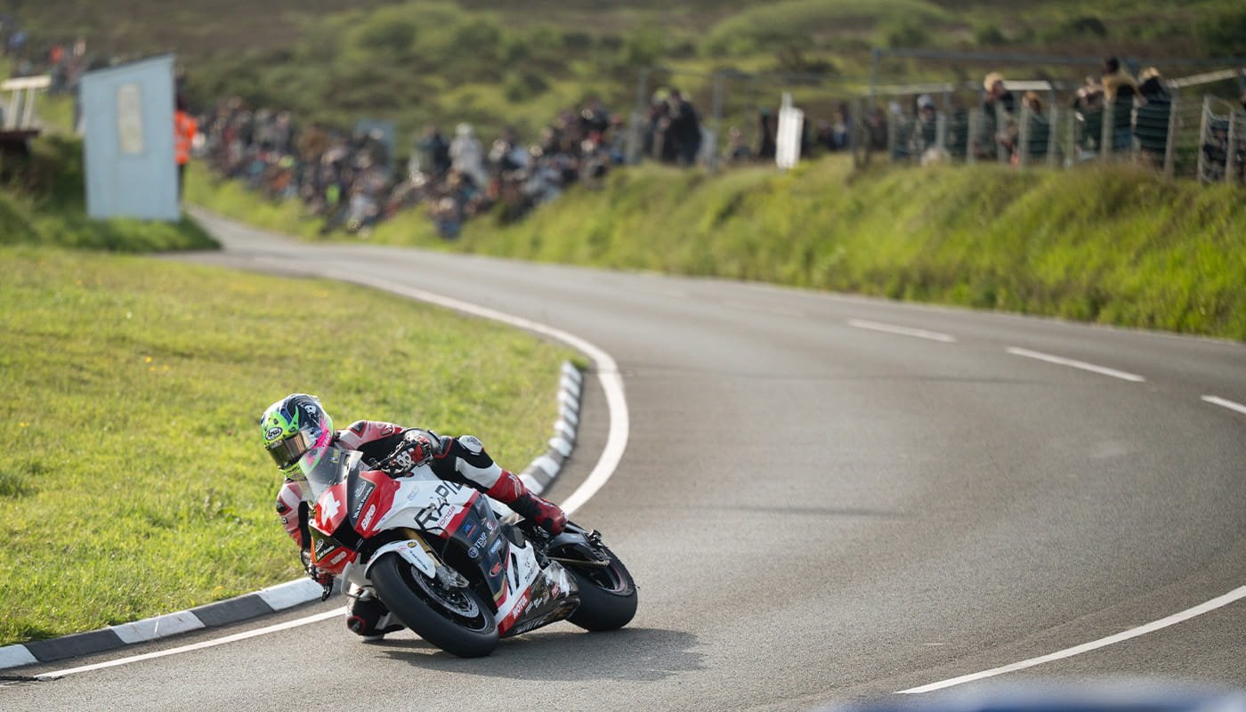 Superbike rider leaning through a bend on the Isle of Man TT course